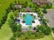 Overhead shot of an inviting community pool with ample seating, palm trees, and nearby playground at 1593 Osprey View Dr, Apopka, FL 32703