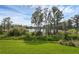Lush backyard view featuring verdant grass, mature trees and tranquil lake views at 17996 Adrift Rd, Winter Garden, FL 34787