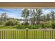 Covered porch view of lush backyard featuring verdant grass, mature trees and tranquil lake views at 17996 Adrift Rd, Winter Garden, FL 34787