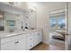 Bright bathroom featuring double sinks, modern lighting, and a view into the main bedroom at 17996 Adrift Rd, Winter Garden, FL 34787