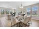 Bright dining area with glass table, seating for six, and adjacent living space with large windows at 17996 Adrift Rd, Winter Garden, FL 34787