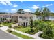 Gorgeous home with a front yard featuring lush landscaping and a serene lake backdrop at 17996 Adrift Rd, Winter Garden, FL 34787