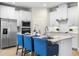Spacious kitchen features a central island, white cabinets, stainless steel appliances and bar seating at 17996 Adrift Rd, Winter Garden, FL 34787