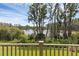 Serene view from the porch overlooking a lush backyard and a tranquil lake with native trees at 17996 Adrift Rd, Winter Garden, FL 34787