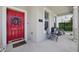 Stylish red front door adorned with a wreath, complemented by seating and the home's address number at 2345 Volunteer Ave, Kissimmee, FL 34744