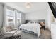 Serene main bedroom with large windows, plush carpeting, and a luxurious gray upholstered bed and adjacent reading chair at 2345 Volunteer Ave, Kissimmee, FL 34744