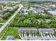 Expansive aerial view showcases townhomes near lush greenery, retail areas, and waterways at 2508 Seven Oaks Dr, St Cloud, FL 34772