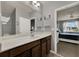 This bathroom features a large mirror, dark wood cabinets, and easy access to a bedroom at 2508 Seven Oaks Dr, St Cloud, FL 34772