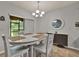 Bright dining room with a large window overlooking the backyard and seating for four around a white wood table at 2508 Seven Oaks Dr, St Cloud, FL 34772