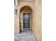 Covered front door entrance with textured walls, arched doorway, and stone tile floor at 2508 Seven Oaks Dr, St Cloud, FL 34772