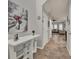 Hallway featuring tile floors and white trim, with a view into the living room with plentiful natural light at 2508 Seven Oaks Dr, St Cloud, FL 34772