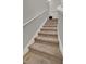 Carpeted staircase with white railings ascending to the upper level of the home at 2508 Seven Oaks Dr, St Cloud, FL 34772