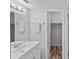 Bathroom featuring a double sink vanity and framed mirror with a view to the walk-in closet at 2517 Caper Ln # 207, Maitland, FL 32751