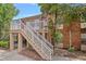Two-story condo building with brick facade, white railings, and stairway with landscaped surroundings at 2517 Caper Ln # 207, Maitland, FL 32751