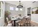 Bright dining room featuring a chandelier, modern table, and minimalist decor for elegant dining at 2541 Leyland Cypress Ln, Sanford, FL 32773