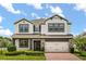 Beautiful two-story home featuring a white stucco facade, stone accents, well-manicured landscaping, and a brick driveway at 2541 Leyland Cypress Ln, Sanford, FL 32773