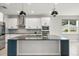 Spacious kitchen with an island, pendant lighting, stainless steel appliances and modern white cabinets at 2541 Leyland Cypress Ln, Sanford, FL 32773