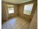 Empty bedroom with tile flooring, two windows letting in natural light, and a standard interior door at 2601 Tennessee Rd, Lakeland, FL 33815