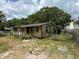 Modest single-story home with yellow siding, mature trees, and a slightly overgrown front yard at 2601 Tennessee Rd, Lakeland, FL 33815