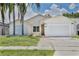 Charming single-story home with a two-car garage and well-maintained exterior, complemented by palm trees at 2742 Woodruff Dr, Orlando, FL 32837