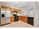 Kitchen featuring wood cabinets, black appliances, a stainless steel refrigerator, and tile floors at 2742 Woodruff Dr, Orlando, FL 32837