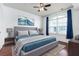 Bedroom with hardwood floors, ceiling fan, and large window; tastefully staged with a bed and decor at 300 E South St # 6016, Orlando, FL 32801