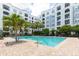 Relaxing pool area surrounded by palm trees, landscaping, and a multi-story condo building at 300 E South St # 6016, Orlando, FL 32801
