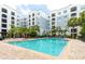 Upscale community pool offering a refreshing escape with multiple lounge chairs and lush landscaping at 300 E South St # 6016, Orlando, FL 32801