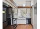 The kitchen features white cabinets, black appliances, wood floor, and an open layout at 3118 S Semoran Blvd # 2, Orlando, FL 32822
