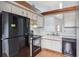 The kitchen has white cabinets, black appliances, a wood floor, and a skylight at 3118 S Semoran Blvd # 2, Orlando, FL 32822