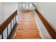 Carpeted stairs featuring a wood banister and a metal railing to the left at 3118 S Semoran Blvd # 2, Orlando, FL 32822