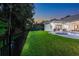Expansive backyard with a lush lawn, fountain pool, privacy fence, and tropical trees at 3316 Regal Crest Dr, Longwood, FL 32779
