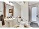 Cozy powder room featuring a pedestal sink, toilet, and shower, with warm neutral tones at 3316 Regal Crest Dr, Longwood, FL 32779