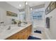 A bright bathroom with double sinks, wood cabinets, and tile flooring at 3316 Regal Crest Dr, Longwood, FL 32779