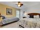 A bright bedroom featuring two beds, ceiling fan, and window with shutters at 3316 Regal Crest Dr, Longwood, FL 32779