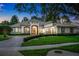 Striking exterior view of a grand home, beautifully landscaped with lush greenery and mature trees at 3316 Regal Crest Dr, Longwood, FL 32779