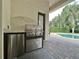 Outdoor kitchen with stainless steel appliances and granite countertop overlooking the pool area at 3316 Regal Crest Dr, Longwood, FL 32779