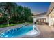 A beautiful pool at dusk with a fountain feature, deck furniture, and tropical landscaping at 3316 Regal Crest Dr, Longwood, FL 32779