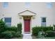 Inviting front entrance with a classic red door, trimmed bushes, and muted neutral stucco at 3569 Seneca Club Loop # 13, Orlando, FL 32808