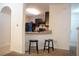 Modern kitchen features sleek, dark cabinetry, tile floors, and countertops, with a view to living area at 3569 Seneca Club Loop # 13, Orlando, FL 32808