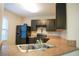 Modern kitchen with dark cabinets, ample counter space and stainless steel appliances at 3569 Seneca Club Loop # 13, Orlando, FL 32808