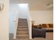 Carpeted staircase with white banister leading to the upper level of the home and next to living room at 3569 Seneca Club Loop # 13, Orlando, FL 32808