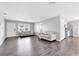 Inviting living room with gray laminate floors, neutral paint, and open access to kitchen at 4006 Kasper Dr, Orlando, FL 32806