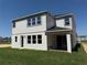 Exterior back view of the two-story home with a covered patio and a spacious lawn at 441 Lady Palm St, Apopka, FL 32703