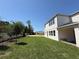 Exterior rear view of the two-story home with a spacious lawn and covered patio at 441 Lady Palm St, Apopka, FL 32703