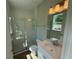 Bathroom featuring glass-enclosed shower, toilet, sink, and vanity mirror at 441 Lady Palm St, Apopka, FL 32703
