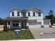 Two-story home boasts a three-car garage, gray accents, and a welcoming front porch at 441 Lady Palm St, Apopka, FL 32703