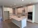 Modern kitchen features white cabinetry, a center island, and stainless steel appliances at 441 Lady Palm St, Apopka, FL 32703