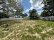 A roomy back yard featuring a shed, mature trees, a white fence, and patchy grass at 4732 Luce Rd, Lakeland, FL 33813