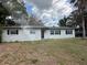 Charming single-Gathering home featuring a classic white facade, black door, and a green lawn at 4732 Luce Rd, Lakeland, FL 33813